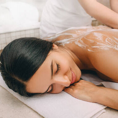 Hammam. Masseur applying foam to a beautiful woman on the body. Woman relaxed in a hammam